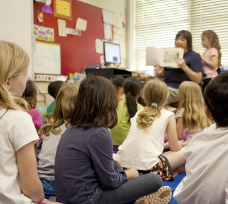 Librarian reading a book to a group of children